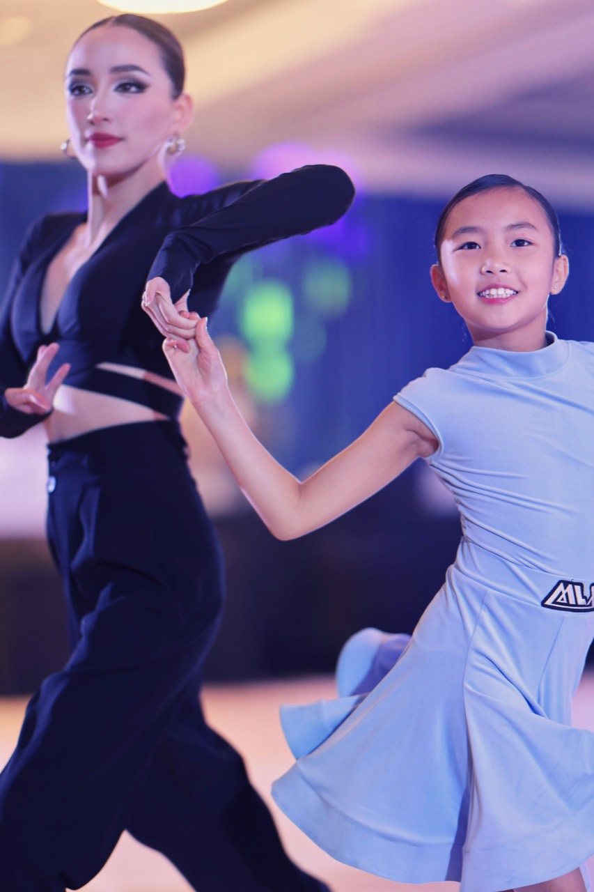 Instructor and youth Latin dancer performing together